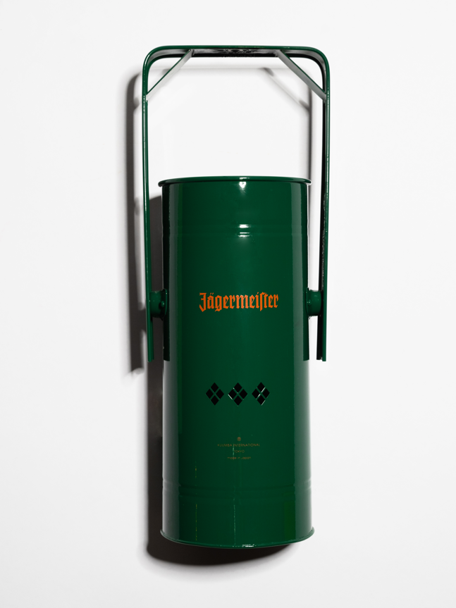 Arzător de tămâie metalic verde, cu mâner și logo-ul Jägermeister portocaliu, pe fundal alb