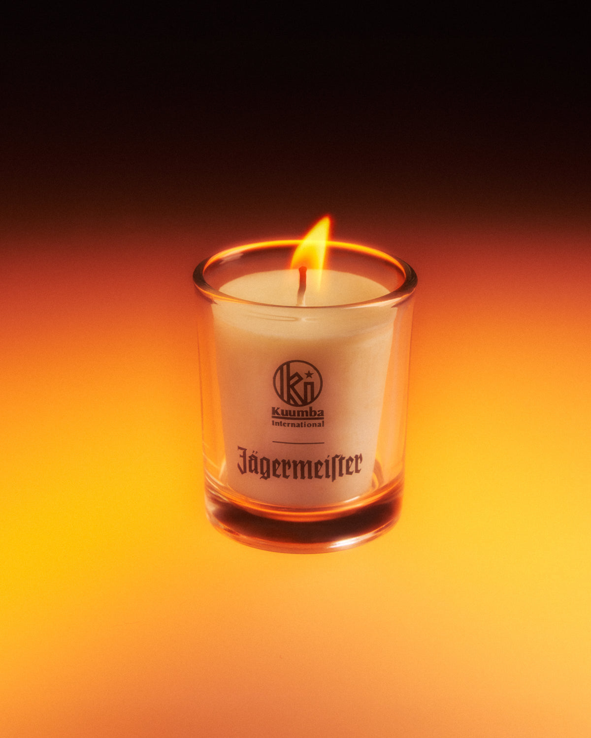 Lumânare Jagermeister într-un recipient de sticlă, cu fundal întunecat