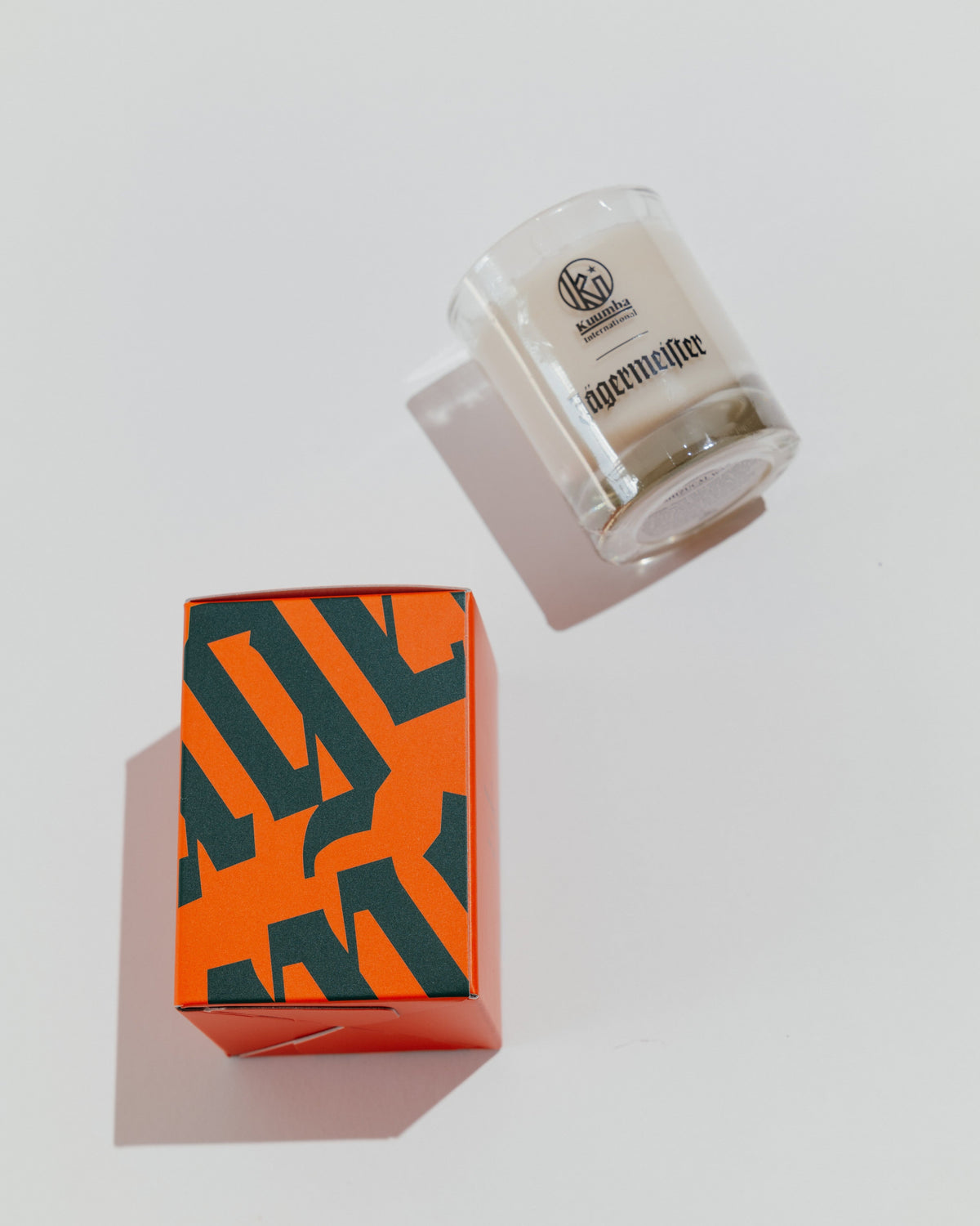 Lumânare Jägermeister cu cutie decorativă, cu wordmark-ul Jägermeister în verde și portocaliu
