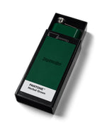 Flască verde cu branding „Jägermeister” într-o casetă neagră etichetată „Pantone Herbal Green”.