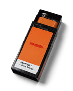 Flască Jägermeister portocalie într-o casetă neagră, cu eticheta „PANTONE Culture Orange” pe fundal alb
