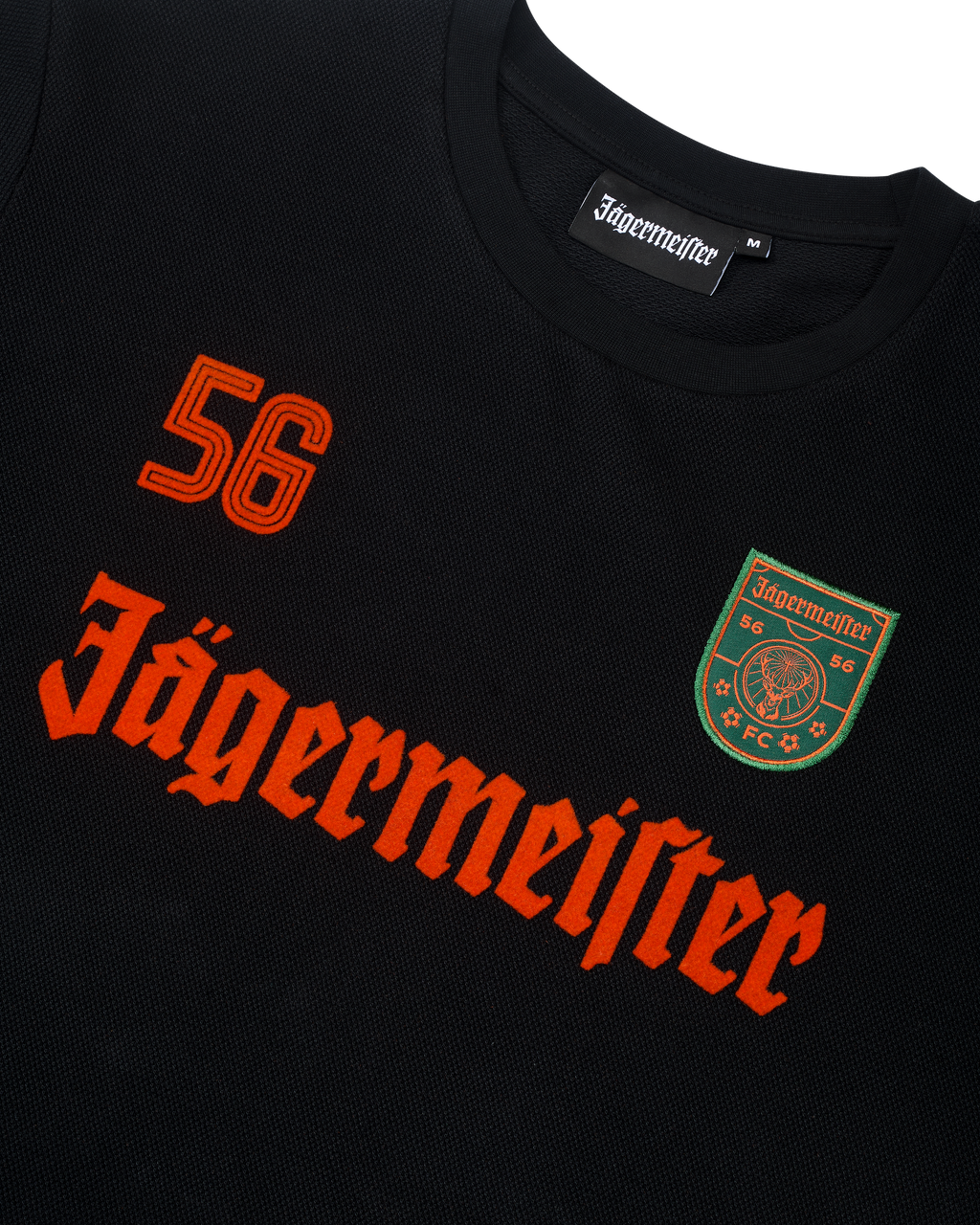 Bluză neagră cu mânecă lungă Jägermeister, cu branding și logo portocalii.
