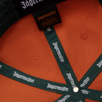 Orange Jägermeister Racing cap with Jägermeister branding on the strap and its label.