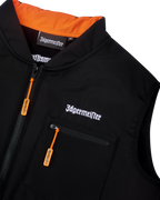 Vestă tactică Jägermeister neagră, cu branding alb Jägermeister în litere și fermoar portocaliu.