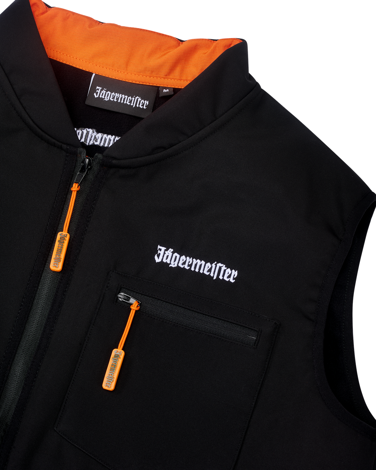 Vestă tactică Jägermeister neagră, cu branding alb Jägermeister în litere și fermoar portocaliu.